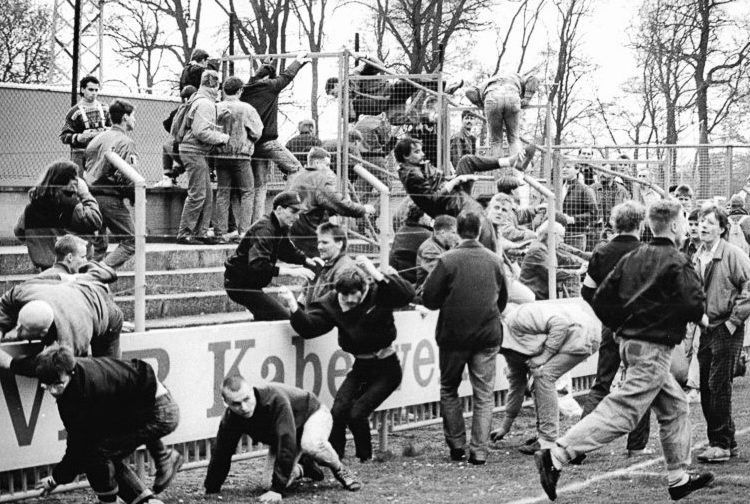 Des hooligans envahissant un stade de football à Leipzig, le 14 avril 1990,
avant un match de la Coupe de la RDA (FDGB-Pokal) entre le 1. FC Lokomotive Leipzig et le Dynamo Schwerin (source : Bundesarchiv, Bild 183-1990-0414-009 - ADN-Zentralbild)